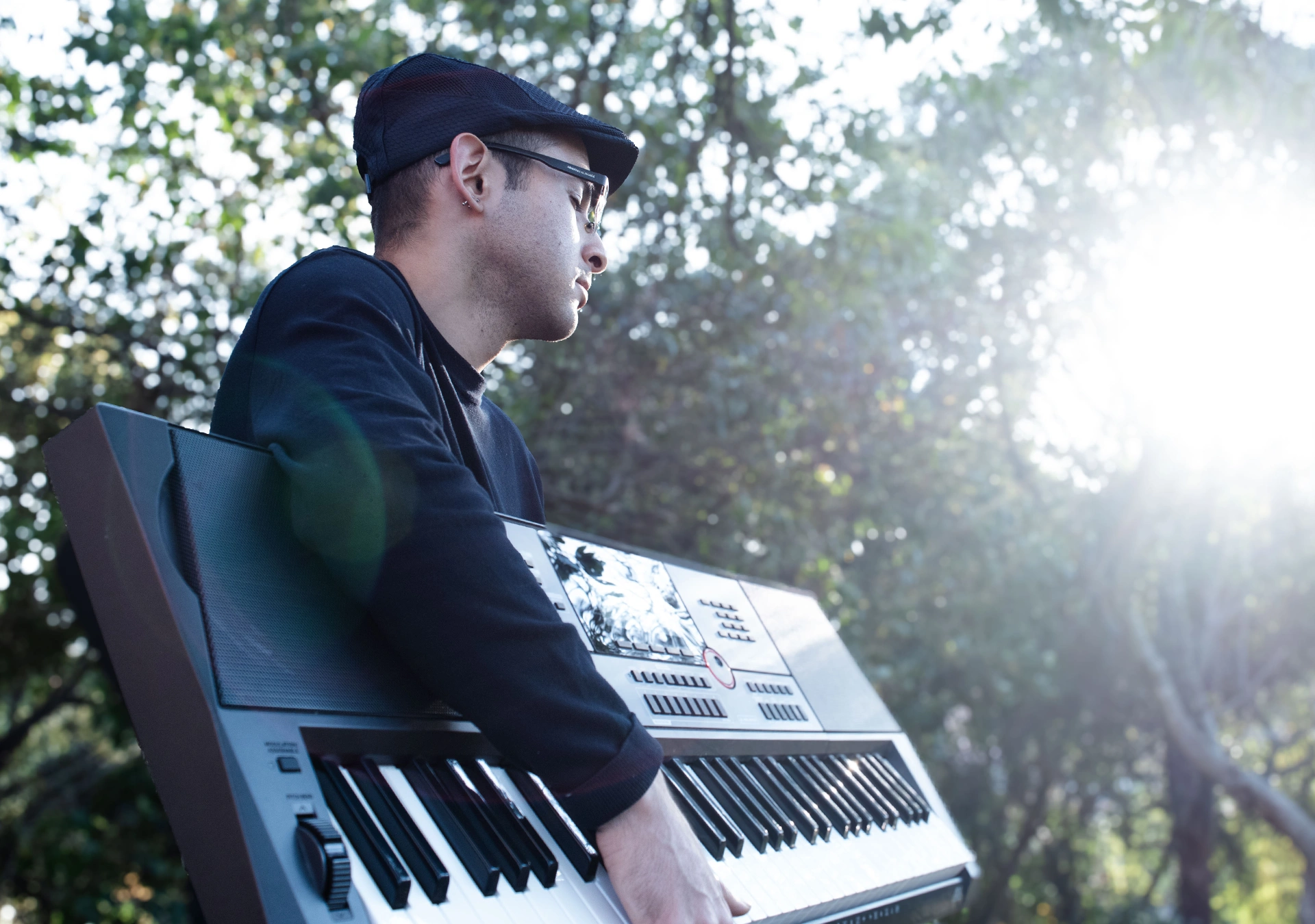 Primer Plano de {{artist}} con un piano al aire libre, redeado de naturaleza